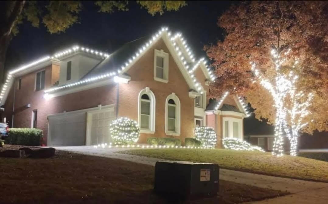 Rooflines & tree wrap Brick home with roofline lights, shrub lights and a wrapped fall tree