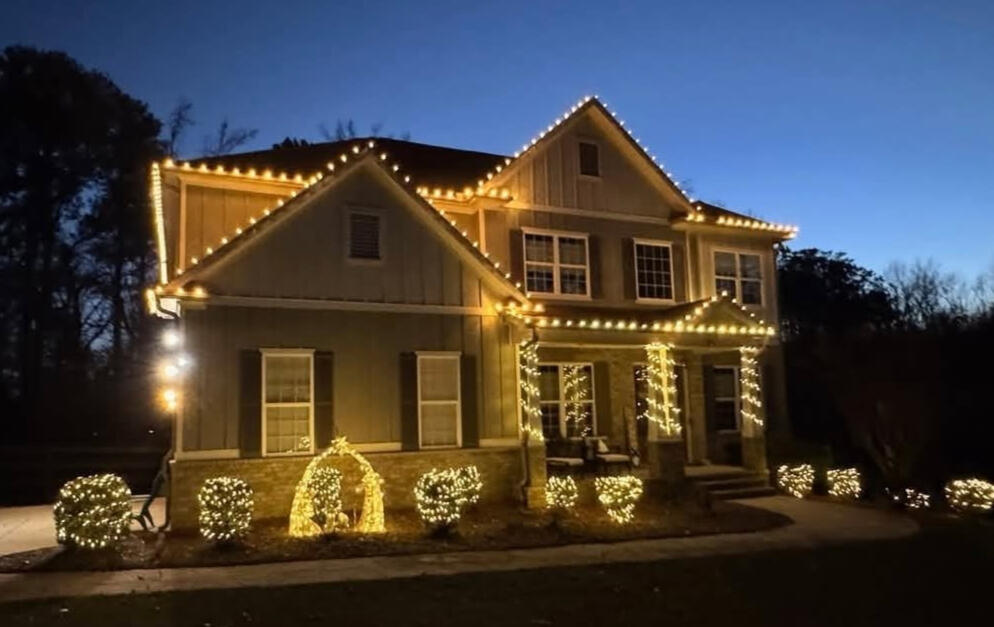 Farmhouse Farmhouse-style home with warm white roofline, column and shrub lighting